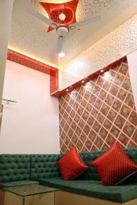 a green couch with red pillows in a room at Madhi Basera in Varanasi