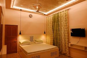 a bedroom with a bed and a television in it at Madhi Basera in Varanasi