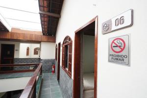 a sign on the side of a building with a no smoking sign at Recanto do Abraao in Abraão