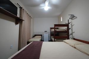 a bedroom with a bed and a flat screen tv at Recanto do Abraao in Abraão