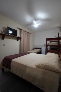 a bedroom with a bed and a flat screen tv at Recanto do Abraao in Abraão