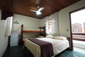 a bedroom with two bunk beds and a window at Recanto do Abraao in Abraão +11 photos