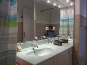 una persona che scatta una foto in uno specchio del bagno di les Beraudes 1 a Névache