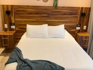 プラヤ・デル・カルメンにあるStudio de luxe Duna 206の木製のヘッドボードが付いたベッドのある寝室 +17枚の写真