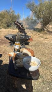 a table with a bottle of beer and a bowl of bread at Capitan de Ansilta in Calingasta +15 photos