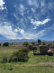 a building in a field with a cloudy sky at Capitan de Ansilta in Calingasta