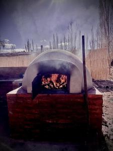 a brick oven with a fire inside of it at Capitan de Ansilta in Calingasta