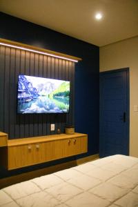 una camera da letto con una TV a schermo piatto su una parete di Ap Da Ilha ad Alter do Chão