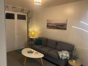 a living room with a couch and a table at Apartment am Waldrand in Itzehoe