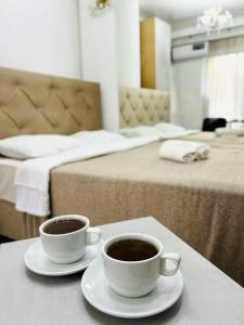 two cups of coffee on a table in a hotel room at CityCenter Studio in Chişinău