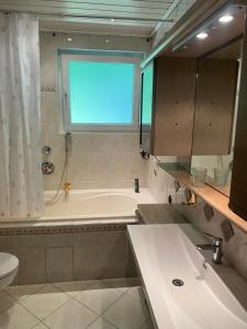 a bathroom with a tub and a toilet and a sink at Apartment am Waldrand in Itzehoe