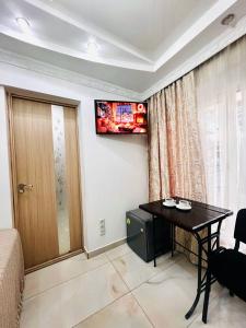 a room with a table and a television on the wall at CityCenter Studio in Chişinău