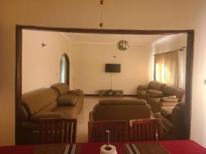 - un salon avec des canapés, un canapé et une télévision dans l'établissement Good Times, à Kampala