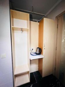 a small kitchen with a tea pot on a shelf at CityCenter Studio in Chişinău