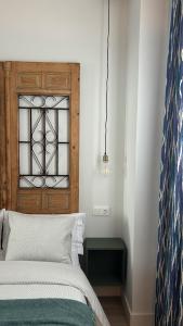 a bedroom with a bed and a window at La Baltasara Apartments in Valladolid