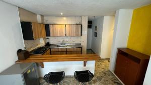 a small kitchen with wooden cabinets and a counter top at Hotel Montecarlo in Cali