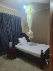une chambre avec un lit sur lequel est posée une fleur dans l'établissement Good Times, à Kampala