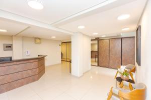 eine Bürolobby mit einer Rezeption und Stühlen in der Unterkunft Edifício La Tour Residence | Centro – Curitiba in Curitiba