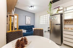 eine Küche und ein Esszimmer mit einem Tisch und einem Kühlschrank in der Unterkunft Edifício La Tour Residence | Centro – Curitiba in Curitiba