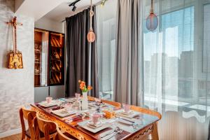 a dining room with a table and a large window at Ulaanbaatar Sky Residence in Ulaanbaatar