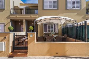 ein Balkon eines Hauses mit einem Tisch und Stühlen in der Unterkunft Bungalow - Playa Maspalomas in San Bartolomé de Tirajana