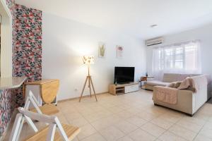 ein Wohnzimmer mit Sofa und Fernseher in der Unterkunft Bungalow - Playa Maspalomas in San Bartolomé de Tirajana