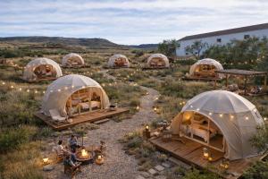 Eine Gruppe von Kuppeln auf einem Feld mit Menschen darin in der Unterkunft Glamping De Castilla in Guadalajara