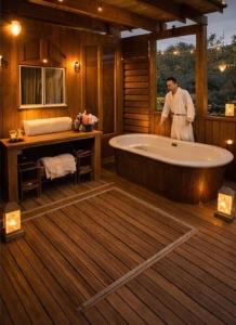 Ein Mann steht in einem Badezimmer mit Badewanne in der Unterkunft Glamping De Castilla in Guadalajara