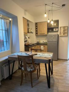 a kitchen with a table and chairs and a refrigerator at Il rifugio di Pongo in Ivrea