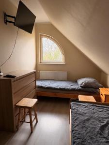 ein kleines Schlafzimmer mit einem Bett und einem Fenster in der Unterkunft GOLENICKA PRZYSTAŃ in Golenice