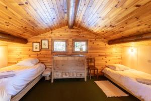 una camera con 2 letti in una baita di tronchi di South-facing Chalet With Views a Le Villard-Late