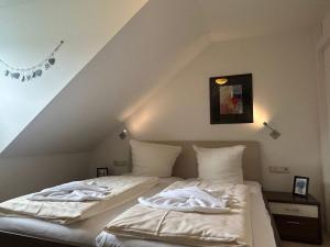 a bedroom with two beds with white towels on them at "Villa Harmonie" direkt am Golfplatz in Göhren-Lebbin