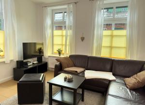 een woonkamer met een bank en een tafel bij Ferienwohnung Medemspeicher in Otterndorf