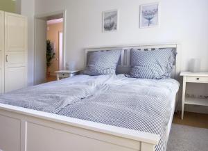 een groot wit bed in een witte slaapkamer bij Ferienwohnung Medemspeicher in Otterndorf