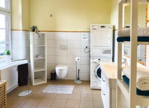 een kleine badkamer met een wasmachine en een wasmachine bij Ferienwohnung Medemspeicher in Otterndorf +10 foto's
