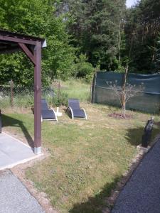 two lounge chairs in a yard with a fence at Haus in Malchow in Malchow +10 photos