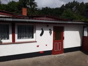 a white and red house with a red door at Haus in Malchow in Malchow