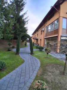 een bakstenen pad voor een gebouw met een boog bij Pensiunea Casa Barsan in Bîrsana +27 foto's