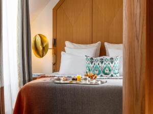a hotel room with a bed with a tray of food on it at Hôtel Vernet Champs Elysées Paris in Paris