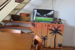 a tv sitting on top of a wooden entertainment center at Duplex Morro de São Paulo in Cairu