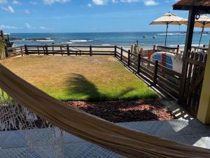a hammock in front of a beach with the ocean at Duplex Morro de São Paulo in Cairu