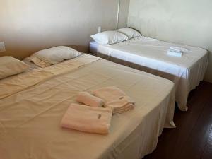 two beds with towels on them in a room at Duplex Morro de São Paulo in Cairu