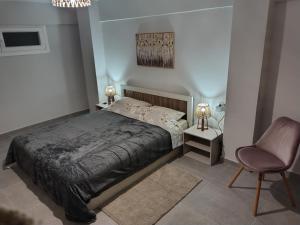 a bedroom with a bed and a chair at Konstantinos Loft in Serres