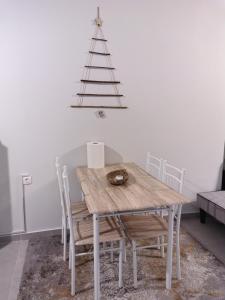 een eettafel met stoelen en een kerstboom bij Konstantinos Loft in Serres