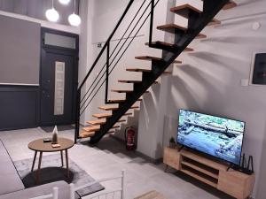 een woonkamer met een trap en een tv bij Konstantinos Loft in Serres