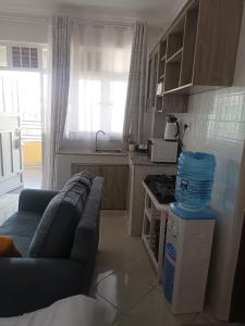 a living room with a couch and a kitchen at Studio BNB Meru town CBD in Meru