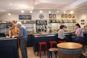 een groep mensen die aan een bar staan bij Le Fin Chapon in Excideuil