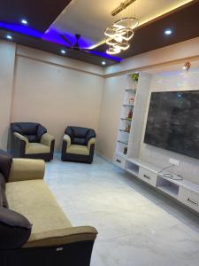 une salle d'attente avec des canapés et une grande télévision à écran plat dans l'établissement Shivasti Heritage Stays, à Jāmb