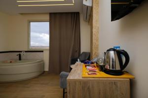 Mazaya Pyramids view inn في Banī Ghālib: غرفة في الفندق مع غلاية الشاي على الطاولة