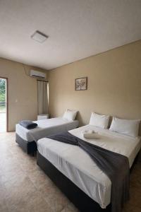 una camera d'albergo con due letti in una stanza di Stallage Hotel a São Pedro